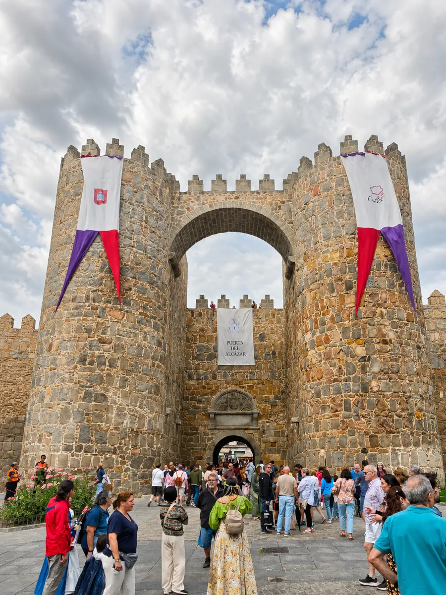Na Puerta del Alcázar, em Ávila, turistas, bandeiras e movimento fazem parte da cena; remover tudo deixaria a foto mais limpa, mas menos verdadeira.