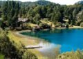 Vista de Llao Llao em Bariloche, com lago azul, vegetação e casas entre as montanhas.