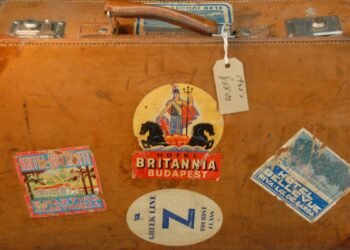 Mala de couro vintage coberta de etiquetas antigas de hotéis e companhias de viagem.