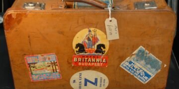 Mala de couro vintage coberta de etiquetas antigas de hotéis e companhias de viagem.