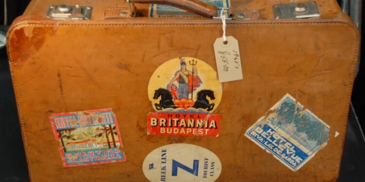 Mala de couro vintage coberta de etiquetas antigas de hotéis e companhias de viagem.