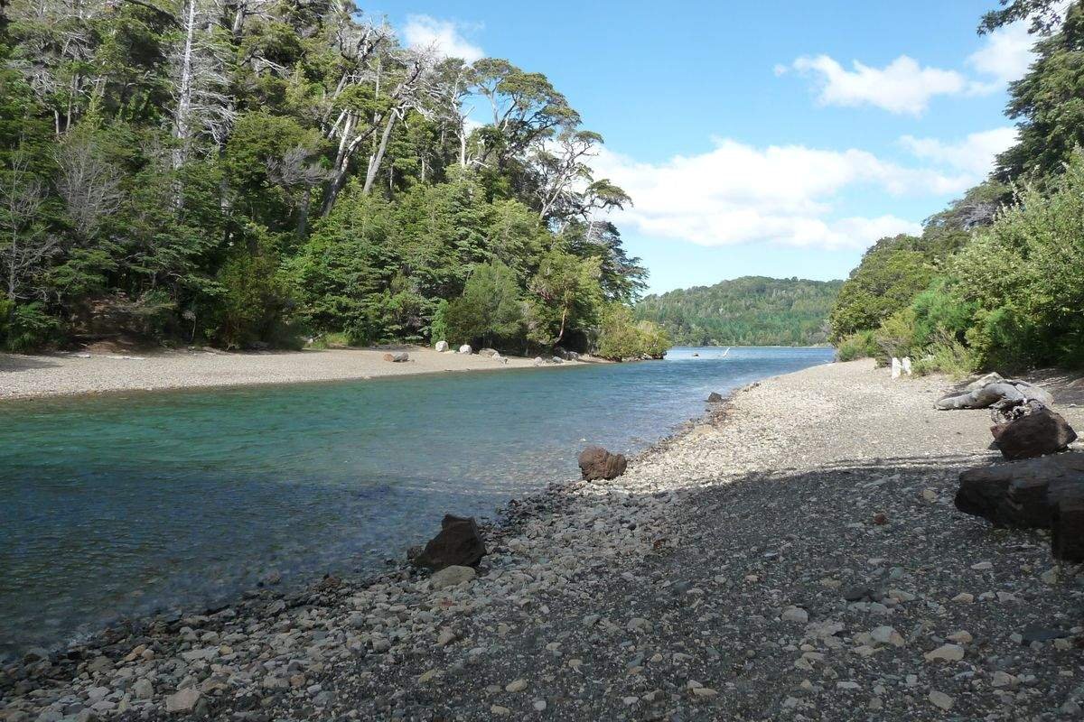 Roteiro de 8 dias em Bariloche 16 Canal entre o lago Moreno e a Bahía López, com praia de pedras e mata ao redor.