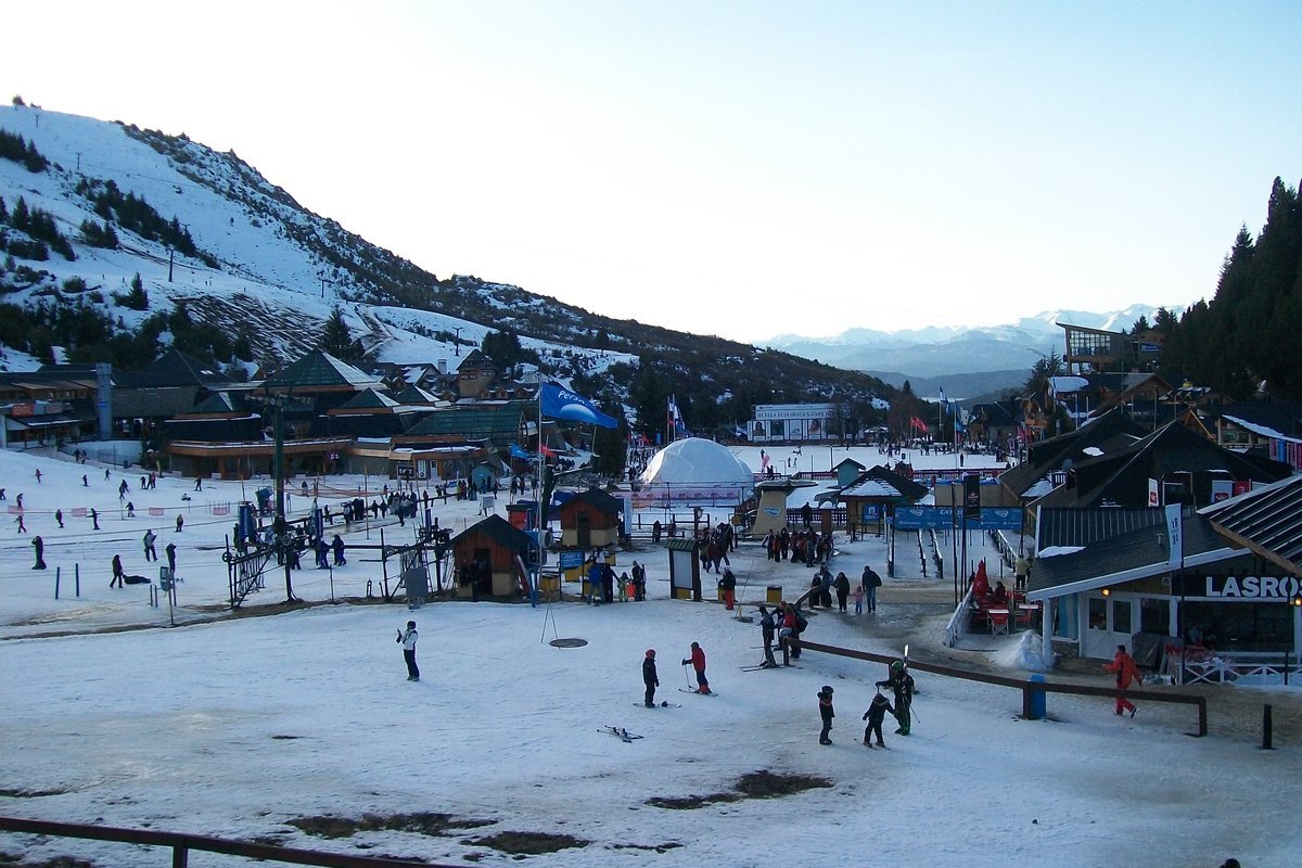 Base do Cerro Catedral em Bariloche no inverno, com neve, esquiadores e montanhas ao fundo.