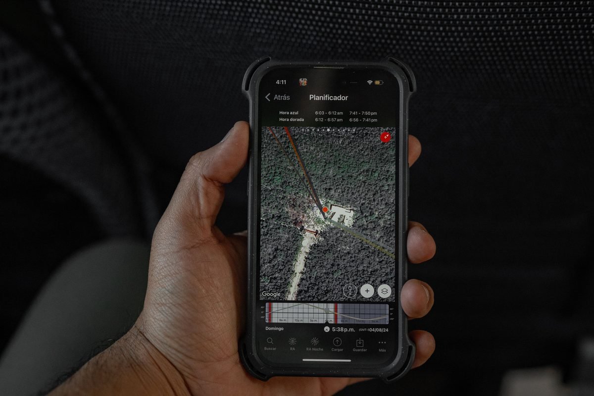 Mão segurando um celular com um mapa aberto na tela.