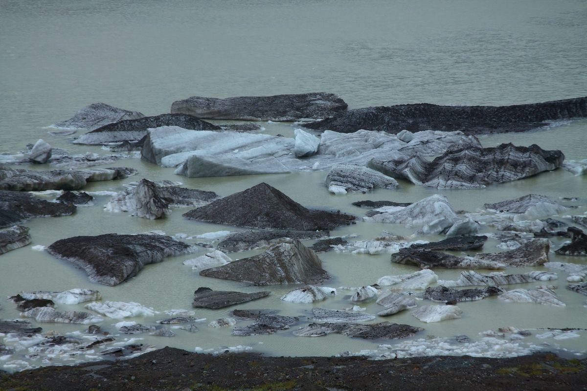 Roteiro de 8 dias em Bariloche 17 Blocos de gelo escuro do Ventisquero Negro flutuando em água esverdeada, no Cerro Tronador.