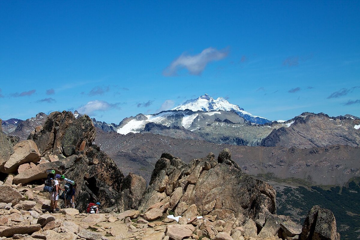 Monte Tronador visto durante trekking na região de Bariloche, com montanhas e neve ao fundo.