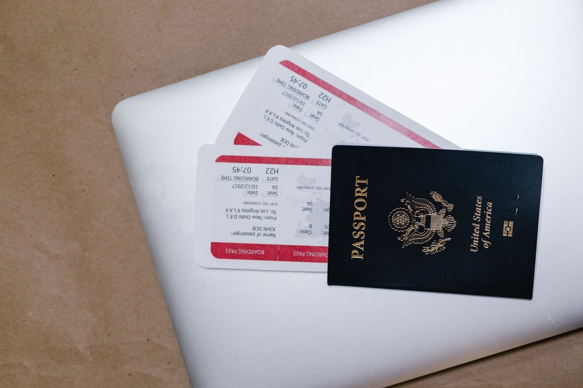 Passaporte e cartões de embarque sobre um notebook, durante o planejamento de uma viagem.
