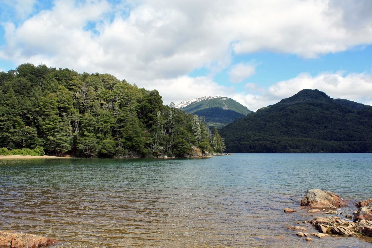 Vista do Lago Mascardi, com água em tons de azul e verde e montanhas ao fundo.