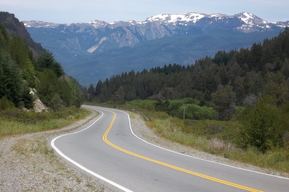 Trecho da Ruta Nacional 40 no departamento de Bariloche, com estrada sinuosa e montanhas ao fundo.