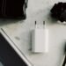 Power bank, carregador, adaptador de tomada e cabo USB-C sobre uma superfície clara.